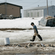 A boy walks along the Newtok River in Newtok, Alaska.